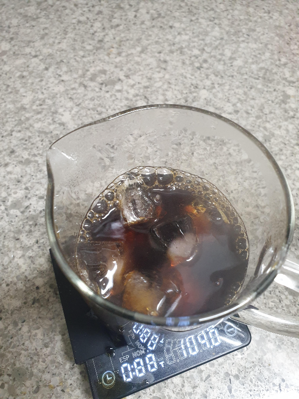 커피가 추출된 서버에 얼음을 추가하고 있는 모습