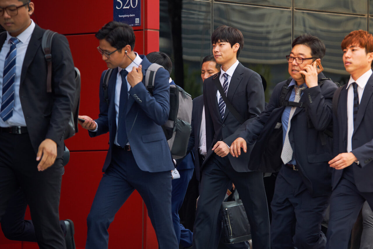 아침 출근길 양복 입은 남자들이 걸어가는 모습