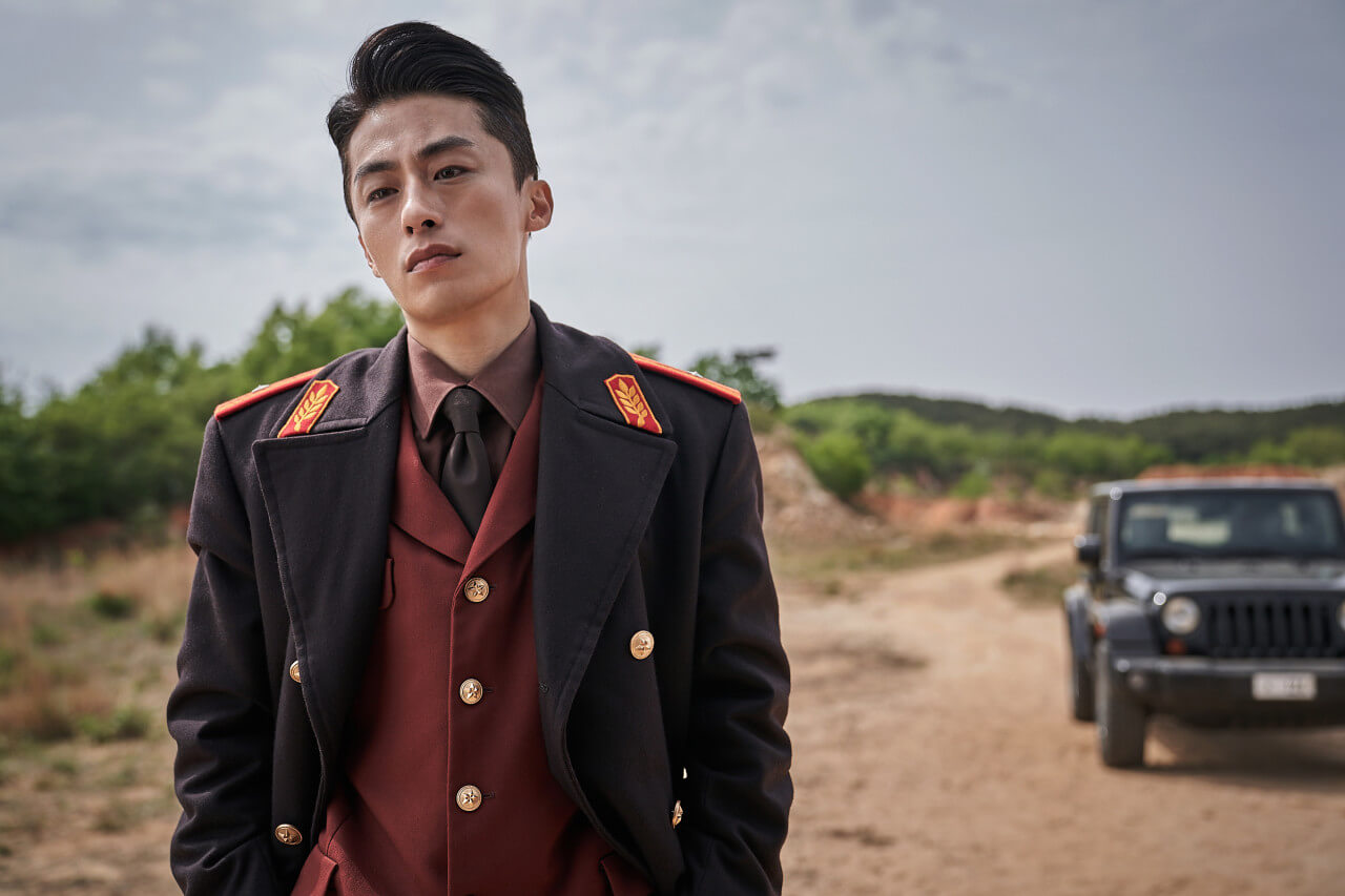 영화 탈주 속 주인공 현상이 제복을 입고 길에 서있는 모습