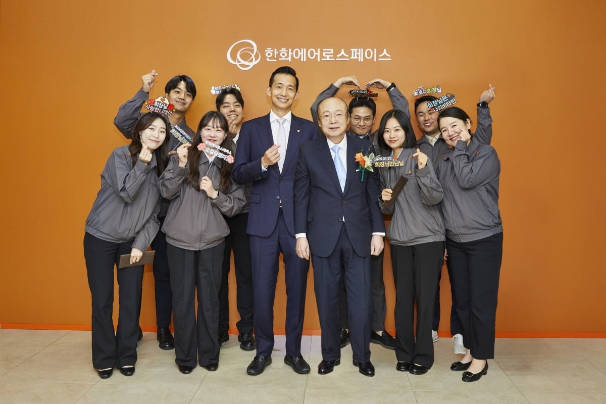 지난 20일 최근 통합 1년을 맞은 한화에어로스페이스 방산부문 창원사업장을 방문한 한화그룹 김승연 회장과 김동관 부회장이 사업장 직원들과 기념 촬영하는 모습.