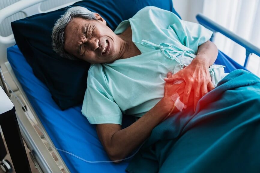 환자가 누워서 배 통증을 힘들어하는 모습