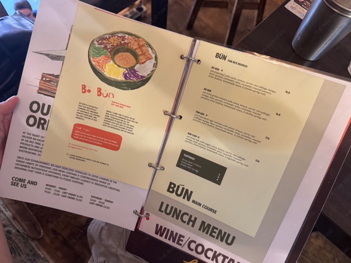The open menu book of Hanoi 1988 showing the Bun menu page with a colorful illustration of a noodle bowl ❘ Le menu ouvert de Hanoi 1988 montrant la page du menu Bun avec une illustration color&eacute;e d'un bol de nouilles