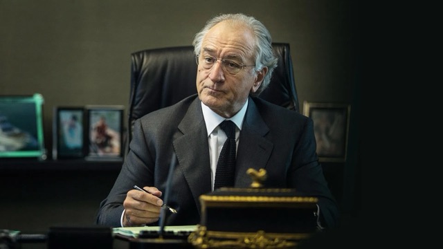 메이도프가 책상 앞에서 펜을 들고 있는 사진