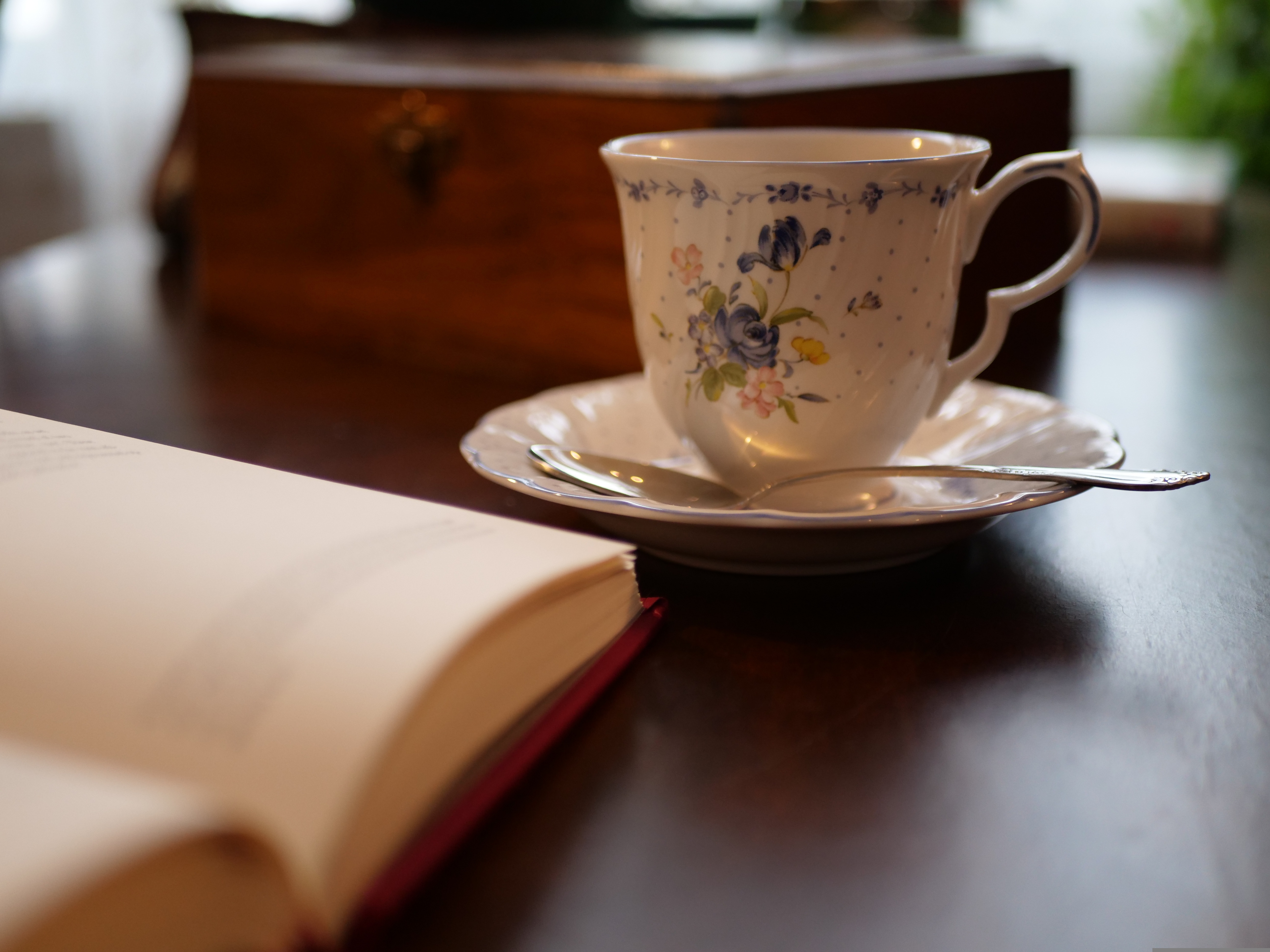 햇살이 들어오는 창가에서 커피와 책이 놓여 있는 조용한 오후 분위기의 감성 관련 사진