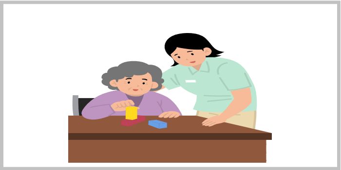 치매 예방을 위한 인지 활동을 돕는 요양보호사와 블록을 쌓고 있는 노인
