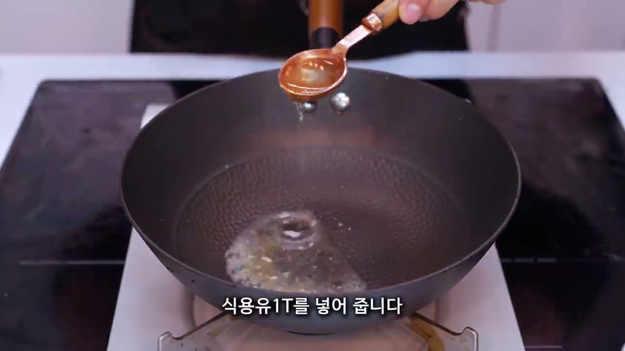 팬에 식용유 1큰술을 넣는 장면