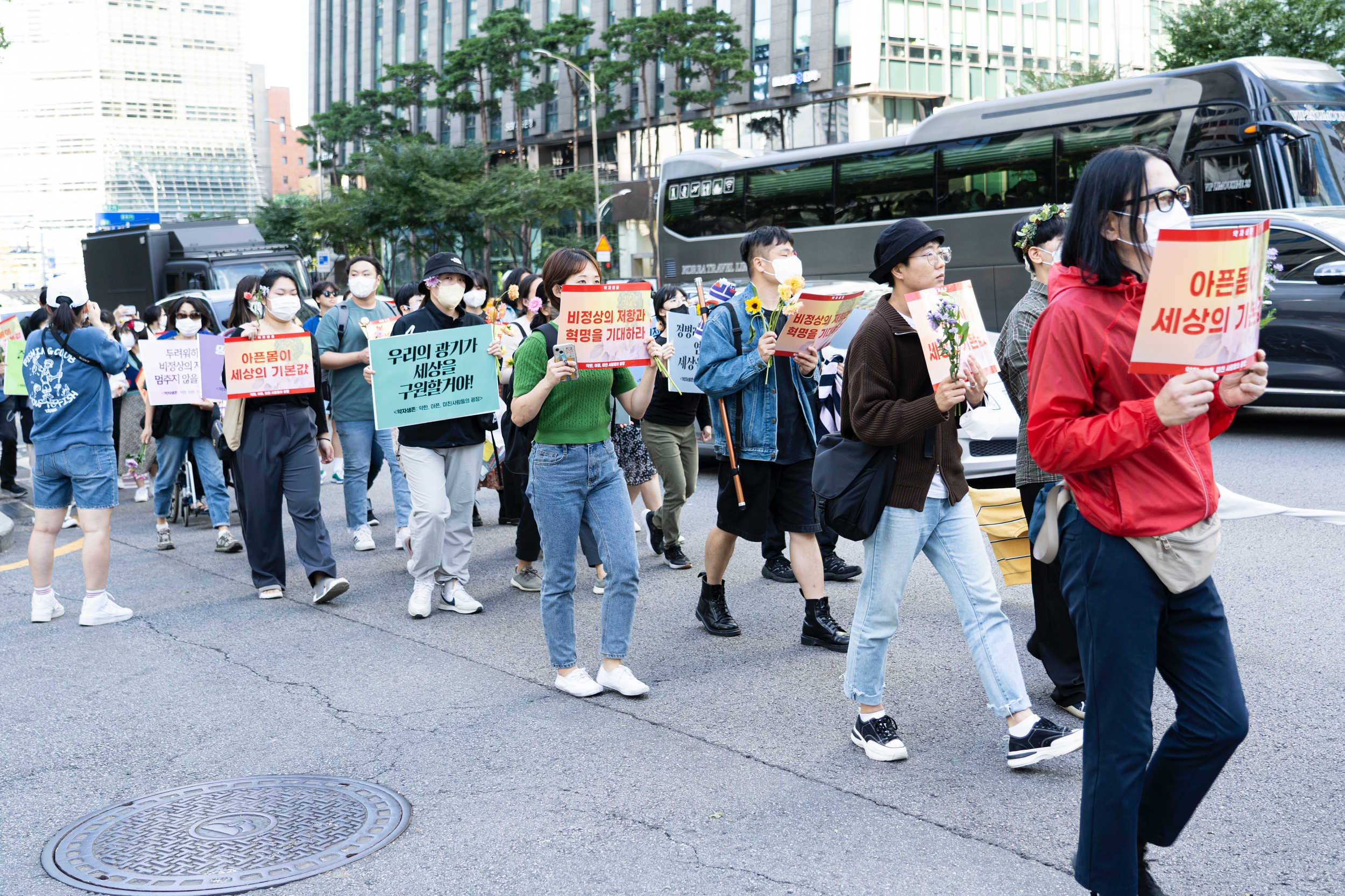 시민들이 피켓과 꽃을 들고 행진하고 있다.