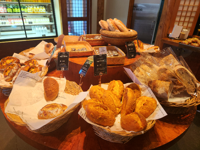 Cornbread, nurungji bread, and baguettes are in a basket.