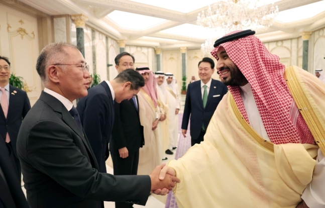 정의선 현대차그룹 회장이 10월 22일(현지 시간) 사우디아라비아 리야드의 야마마궁에서 윤석열 대통령과의 한&middot;사우디 확대회담을 마치고 오찬장으로 향하는 무함마드 빈 살만 빈 압둘아지즈 알 사우드 왕세자 겸 총리와 악수하고 있다.