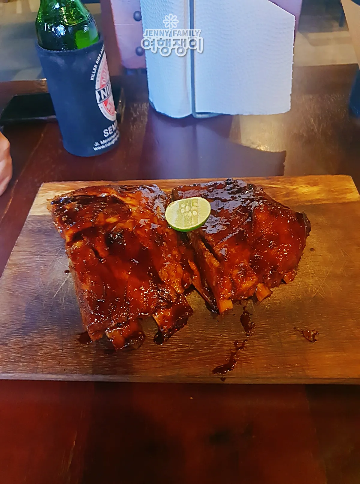 발리 스미냑 너티 누리스 BBQ 폭립, 라임 올린 나무 플래터 — Naughty Nuri’s Seminyak BBQ pork ribs with lime on a wooden platter.