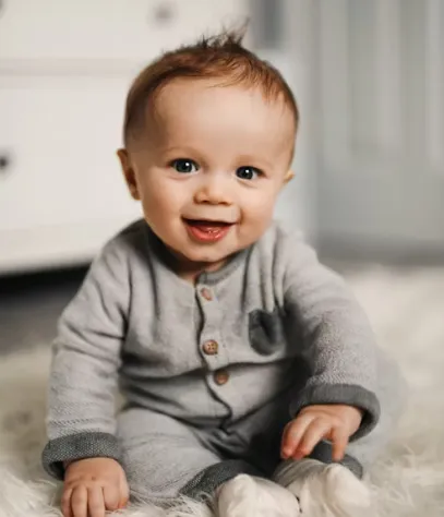 첫만남이용권으로 산 옷을 입고 좋아하는 아기