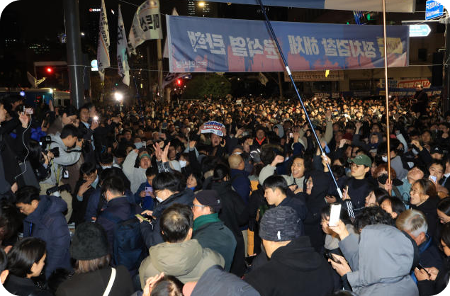 지난해 12월 4일 새벽 국회 앞에서 시민들이 국회 계엄 해제 요구안 가결 소식을 듣고 기뻐하고 있다. [사진=연합뉴스]
