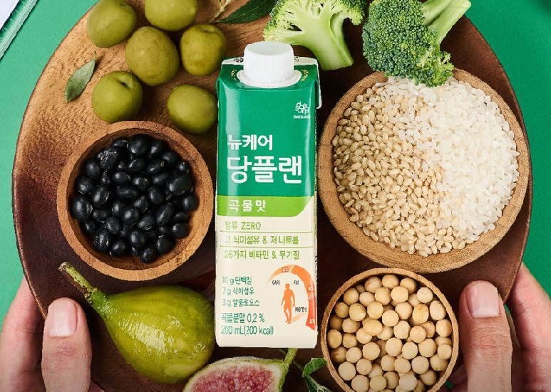 각종-곡류와-채소에-둘러싸여-있는-뉴케어-당플랜-곡물맛-초록색-패키지