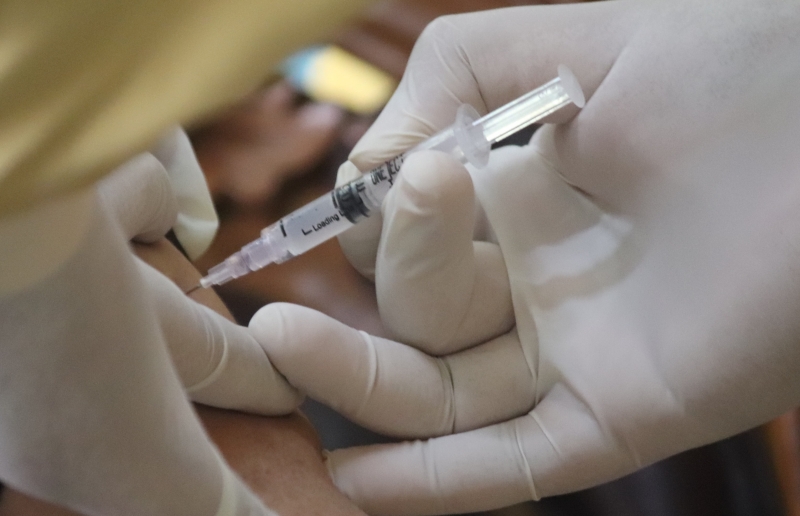 팔에 주사를 놓고 있는 사진