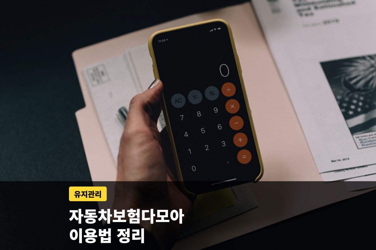 스마트폰 계산기를 누르는 손과 서류 더미