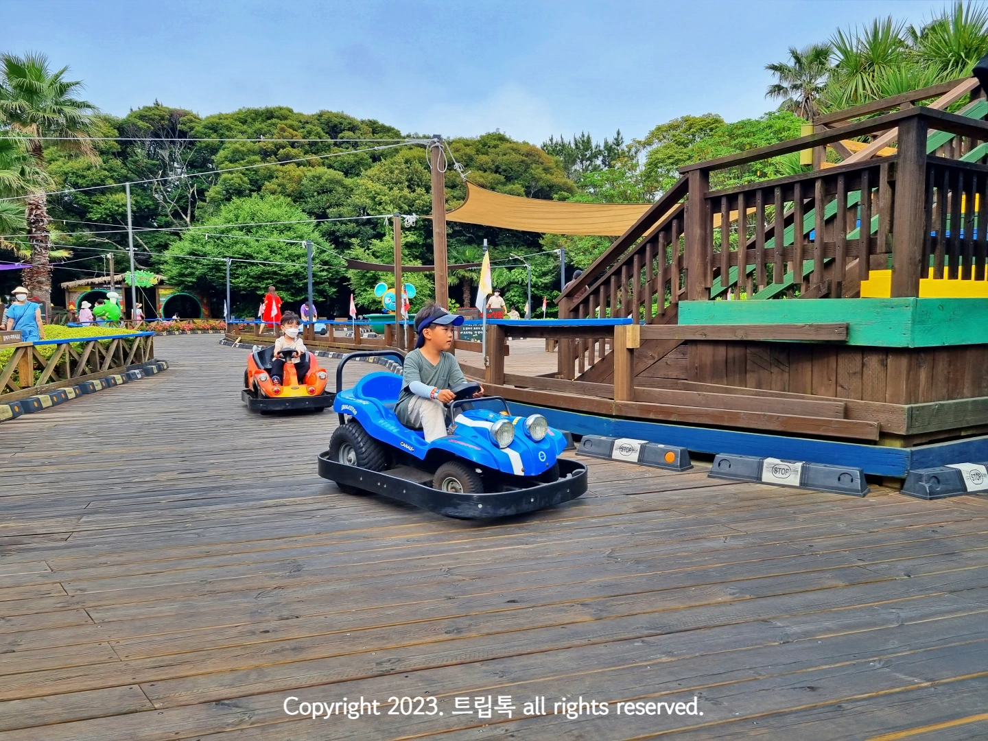 파란색 카트를 운전하고 있는 아이