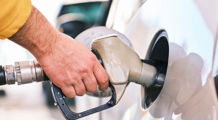 차량 주유 중인 손. 유류세 인하 연장 조치를 시각적으로 표현한 이미지