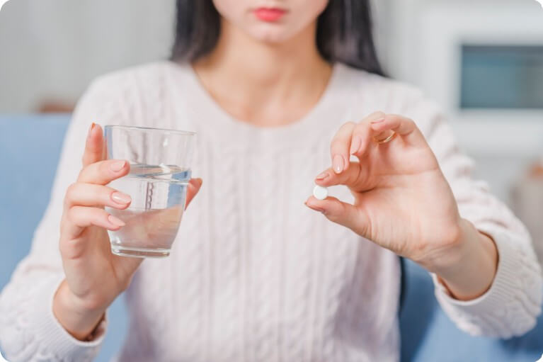 알약을 먹으려고 들고 있는 여성
