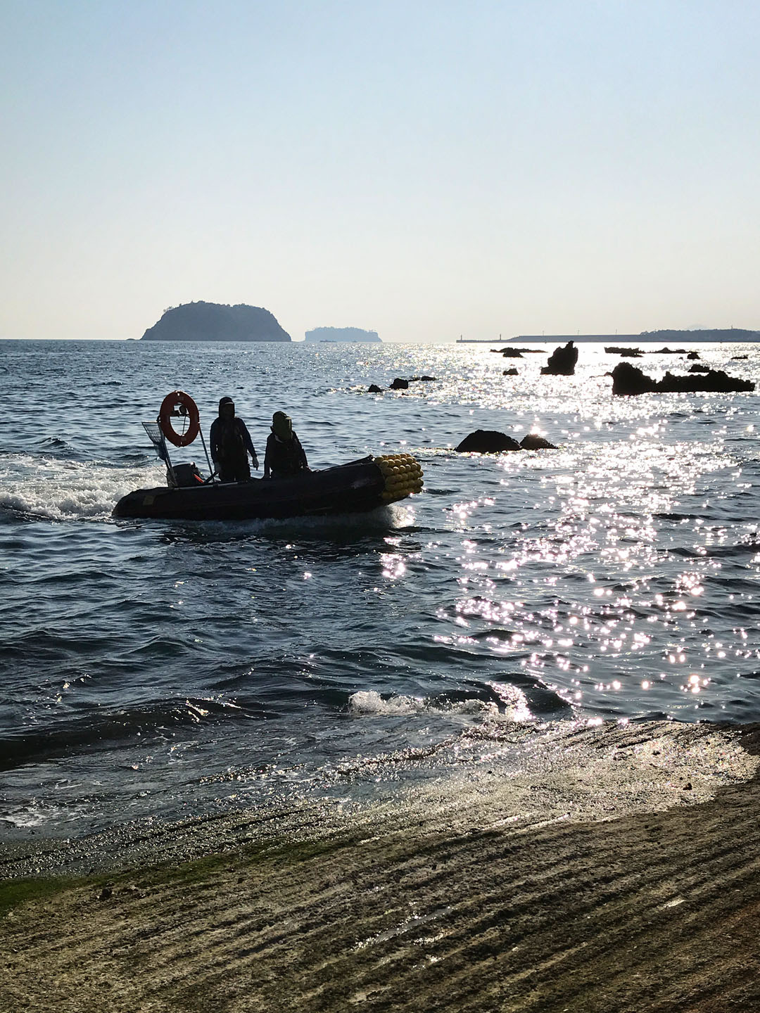 바다에서 보트를 타고 육지로 들어오는 사람들