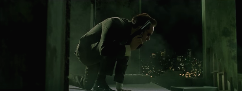 정장을 입고 총을들고 착지하는 모습