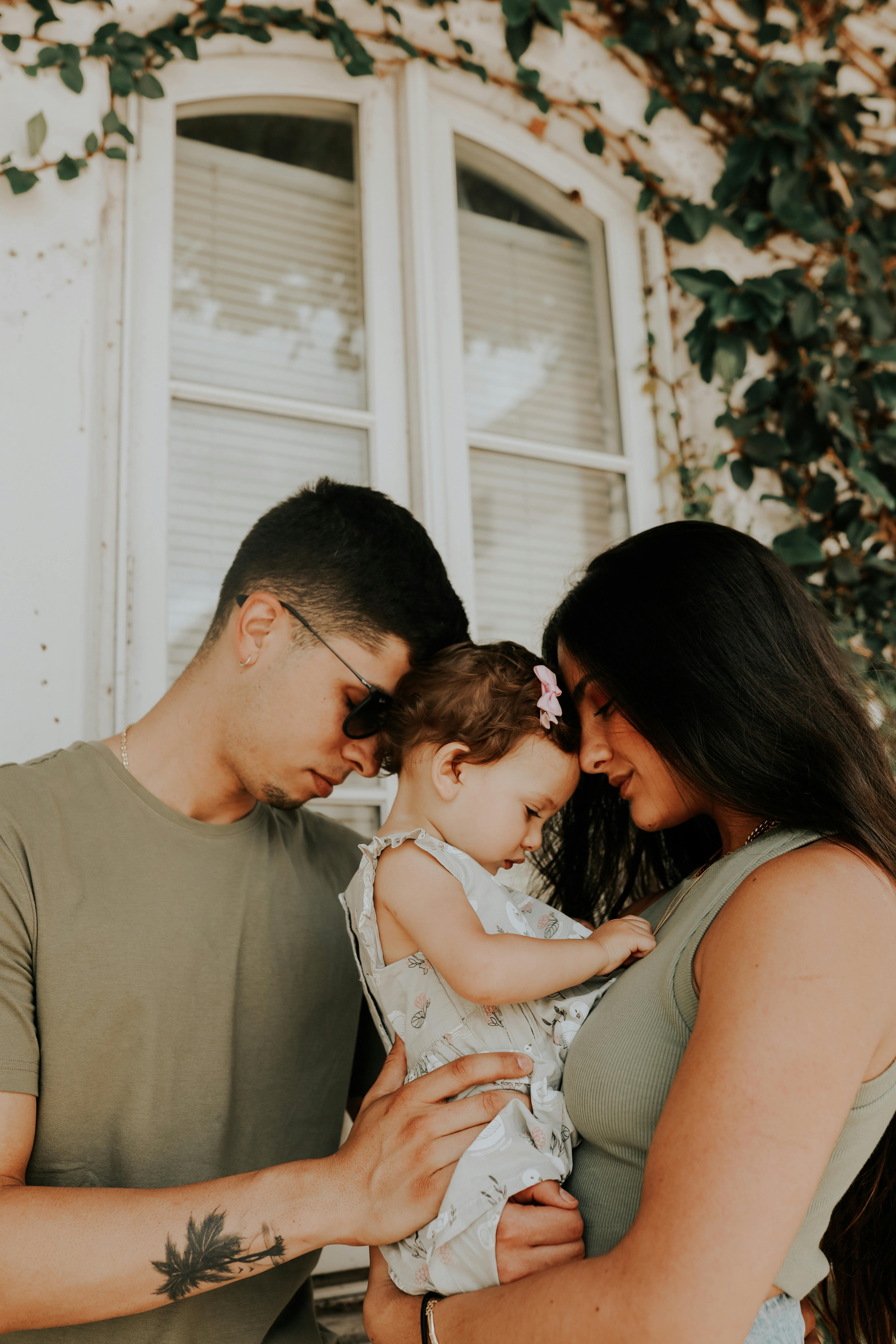 엄마와 아빠가 함께 딸을 안고 있는 사진