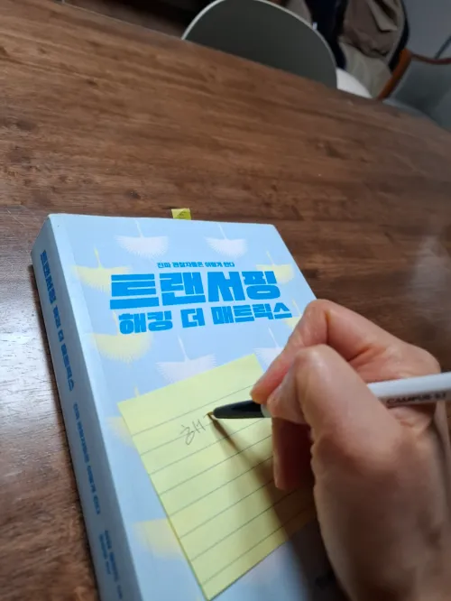 해킹 더 매트릭스 도서 표지 위에 핵심 통찰이 적힌 포스트잇이 붙어 있는 모습 (A post-it note with key insights written on it attached to the cover of the book 'Hacking the Matrix')