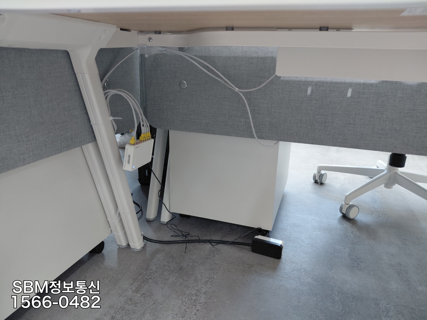 사무용 책상 하단에 스위칭 허브를 단단히 고정하고 바닥에 랜선이 끌리지 않도록 공중으로 배선한 모습