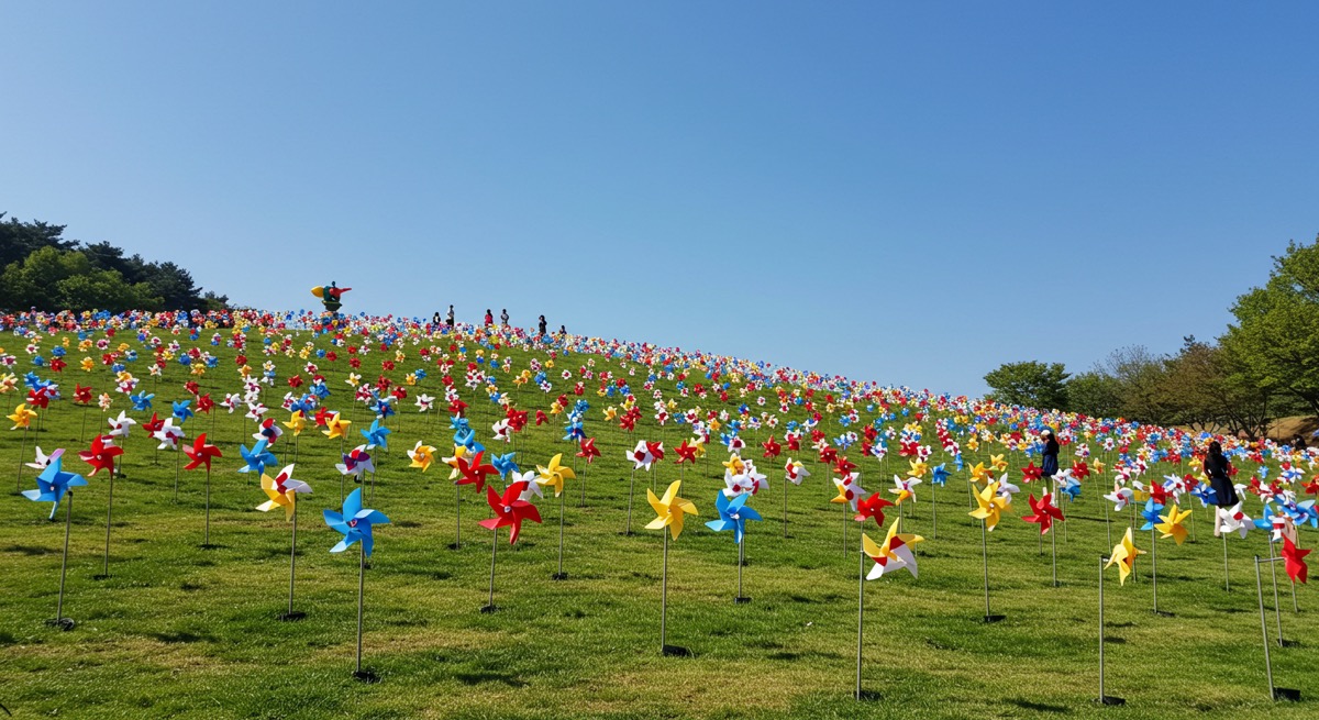 파란 하늘 아래 다채로운 색상의 바람개비가 돌아가고 있는 파주 임진각 평화누리공원의 바람의 언덕 전경