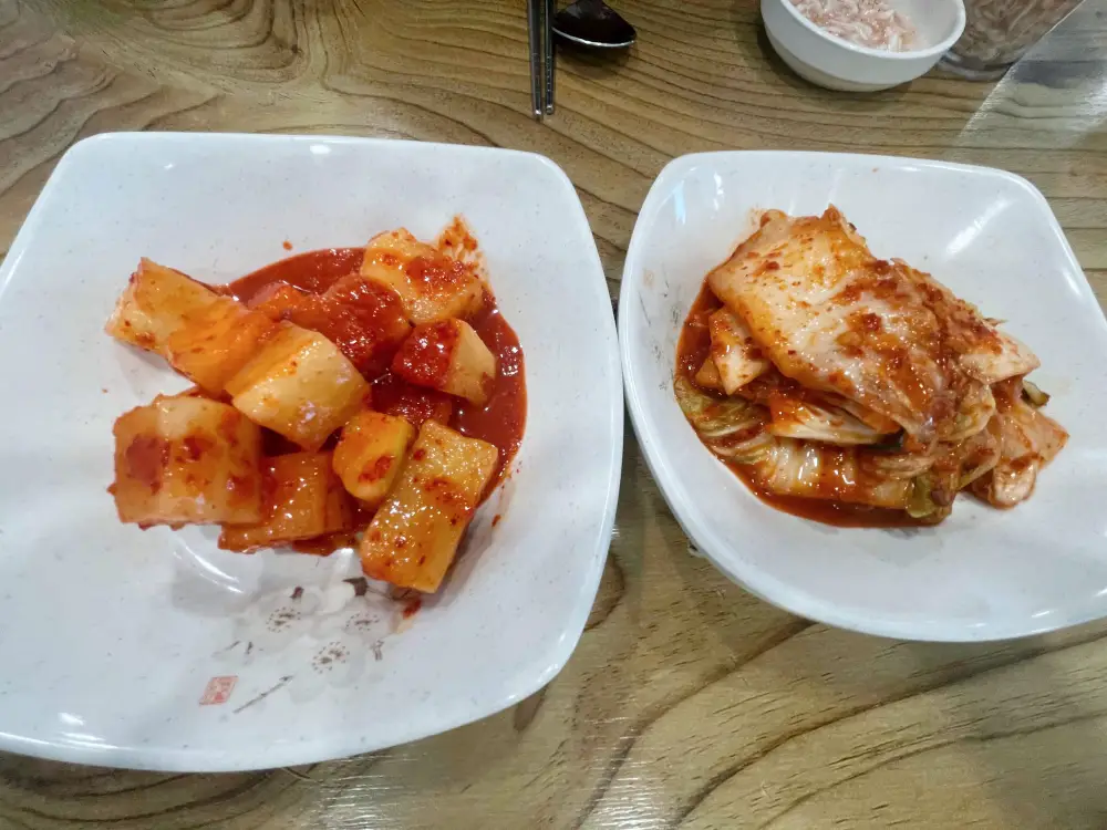 깍두기와 김치가 접시에 담겨진 모습