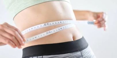 줄자로 배 둘레를 재고있는 여성 사진