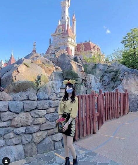 돌벽뒤로 성이 보이는 곳에 서 있는 여성