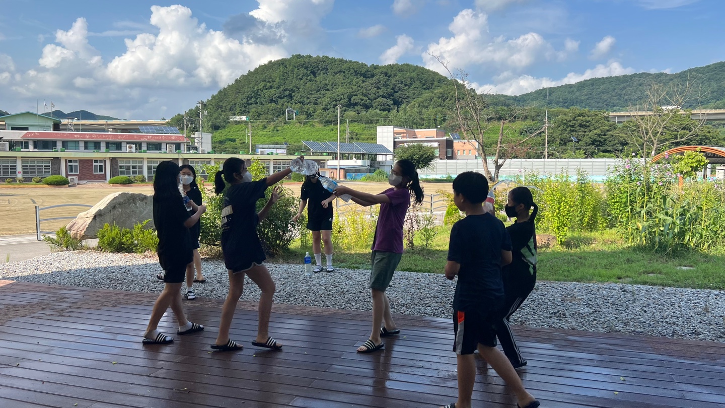 작은도서관 옆 야외 공간에서 함께 물놀이하는 아이들