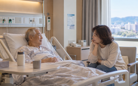 1인실에서 조용히 시간을 보내는 고령의 아버지와 곁에 있는 중년 딸