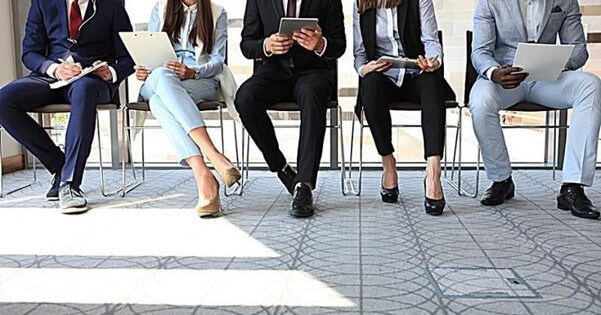 면접-대기실에서-다섯명의-지원자가-템플릿과-기타-서류를-보면서-면접을-준비하는-모습