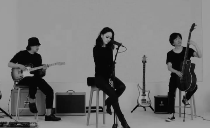 자우림의 단체 사진으로 각자의 자리에 앉아 기타를 치고 노래를 하고 베이스를 치는 사진