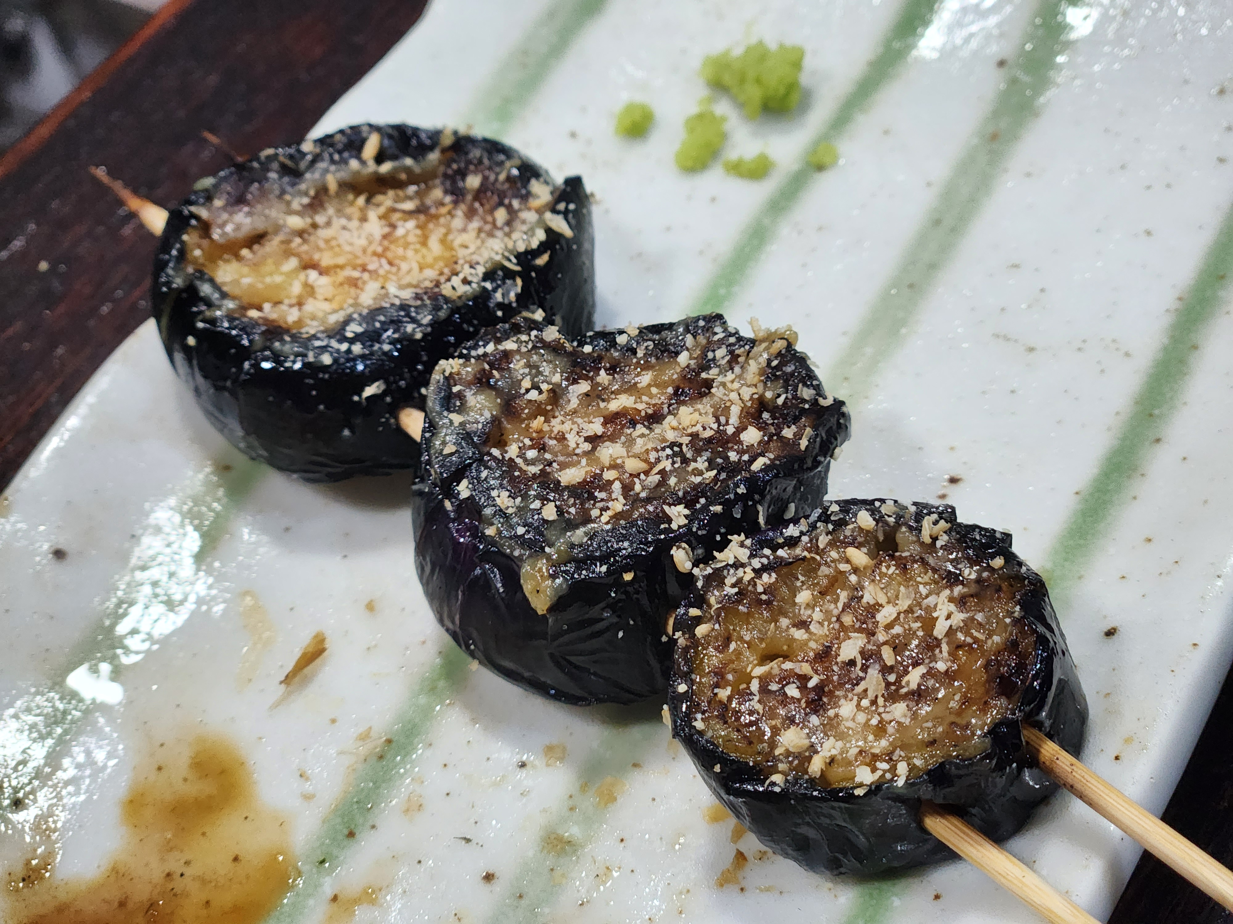 구운 가지 꼬치, 고소한 깨가 뿌려져 감칠맛을 더한 모습