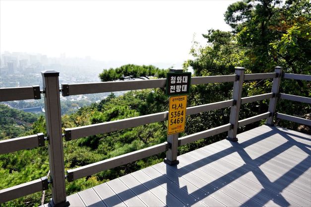 전망대 안전난간 전면에 청와대전망대라는 표식이 붙어 있습니다. 바닥에 길게 드리워진 난간 그림자,