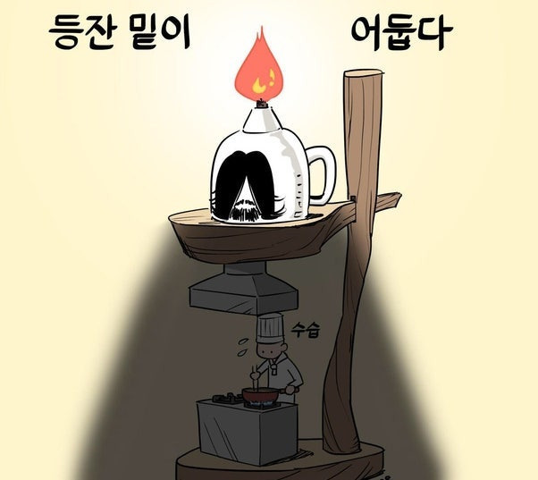 등잔불 아래 요리하는 사람 사진