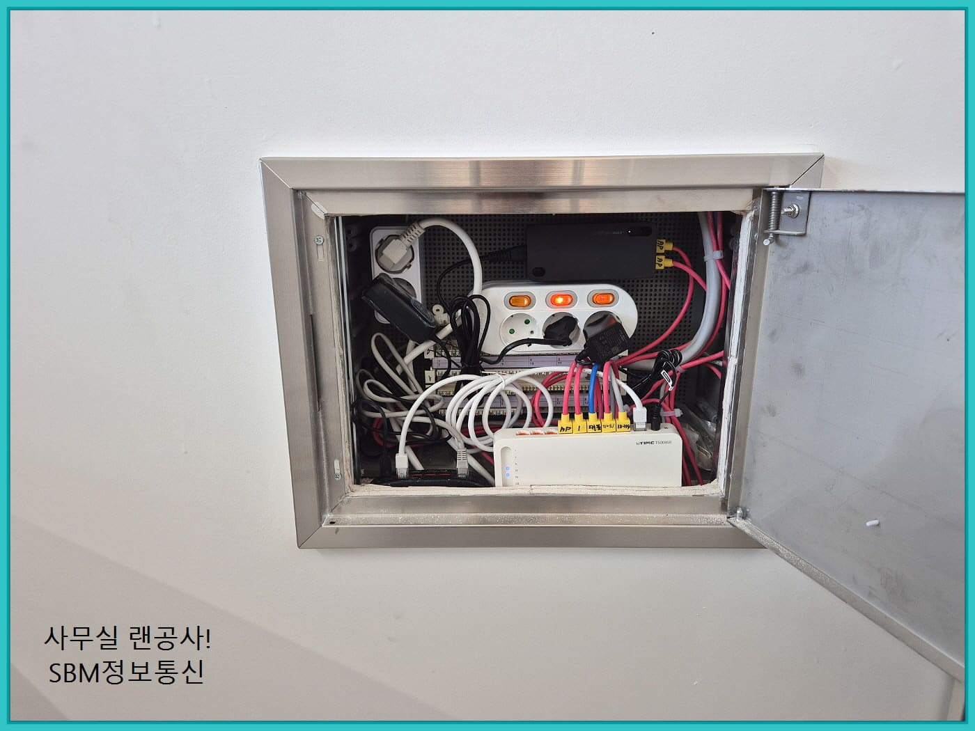 벽면 함체 내부에 멀티탭, 공유기, 허브가 오밀조밀하게 정리된 모습