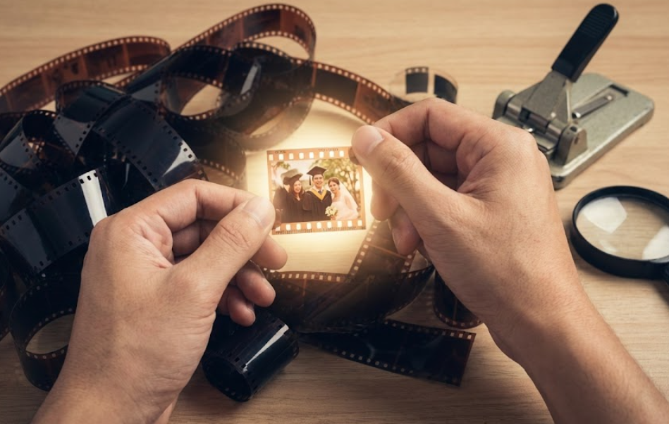 수많은 필름 더미 속에서 행복한 순간이 담긴 하이라이트 필름 컷 하나를 손으로 골라내는 모습