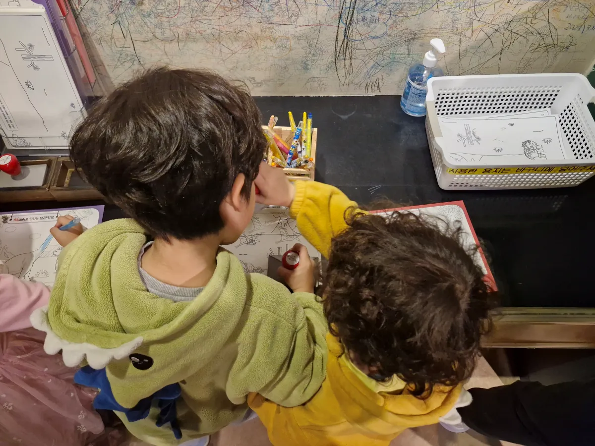 공룡캐릭터를-그리고-있는-두-아이들