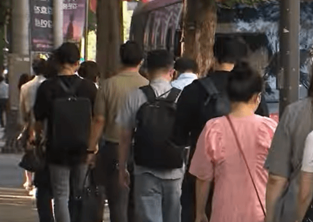 버스를 타려는 사람들이 줄 서있는 장면