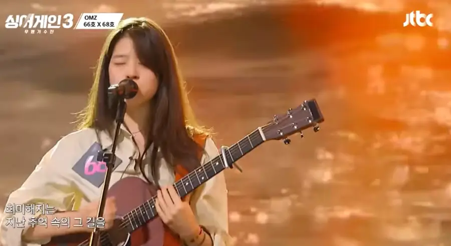 싱어게인3-
흰셔츠 갈색기타를 치며 긴생머리를 늘어뜨린채 스탠딩마이크앞에서 두눈을 감고 노래하는 68호