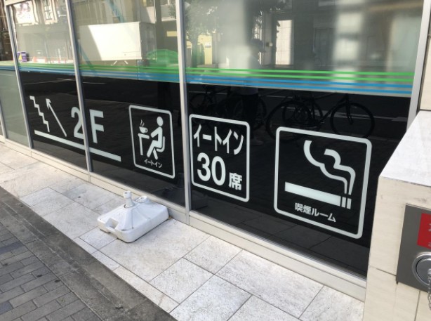 일본 편의점 외관에 흡연실이 있다는 표시의 기호가 붙어 있다