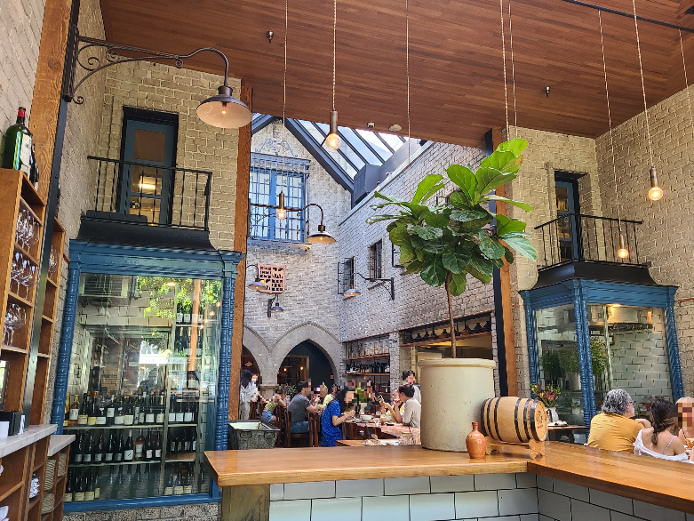 Republique Cafe Bakery의 내부. 천장이 유리로 되어 있어 L:A의 채광이 내부를 밝혀준다. 그 아래로 긴 테이블이 있고 사람들이 브런치를 즐기고 있다.