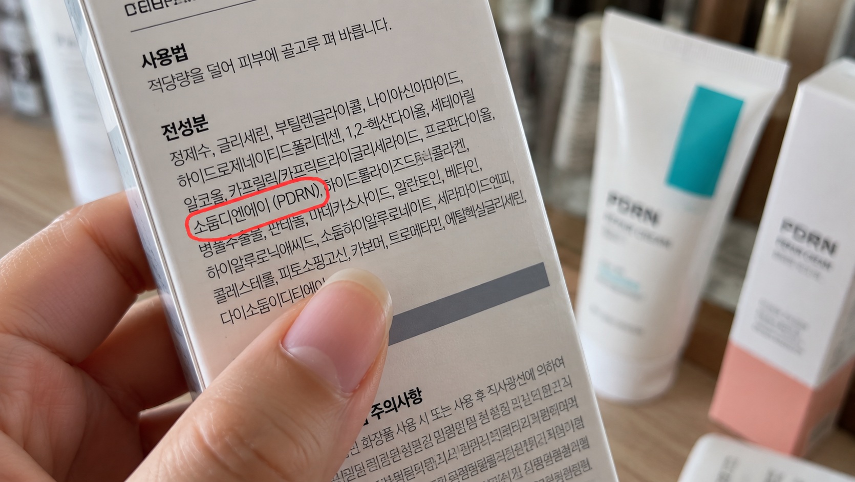 재생크림 전성분표에서 PDRN 성분을 확인하는 모습