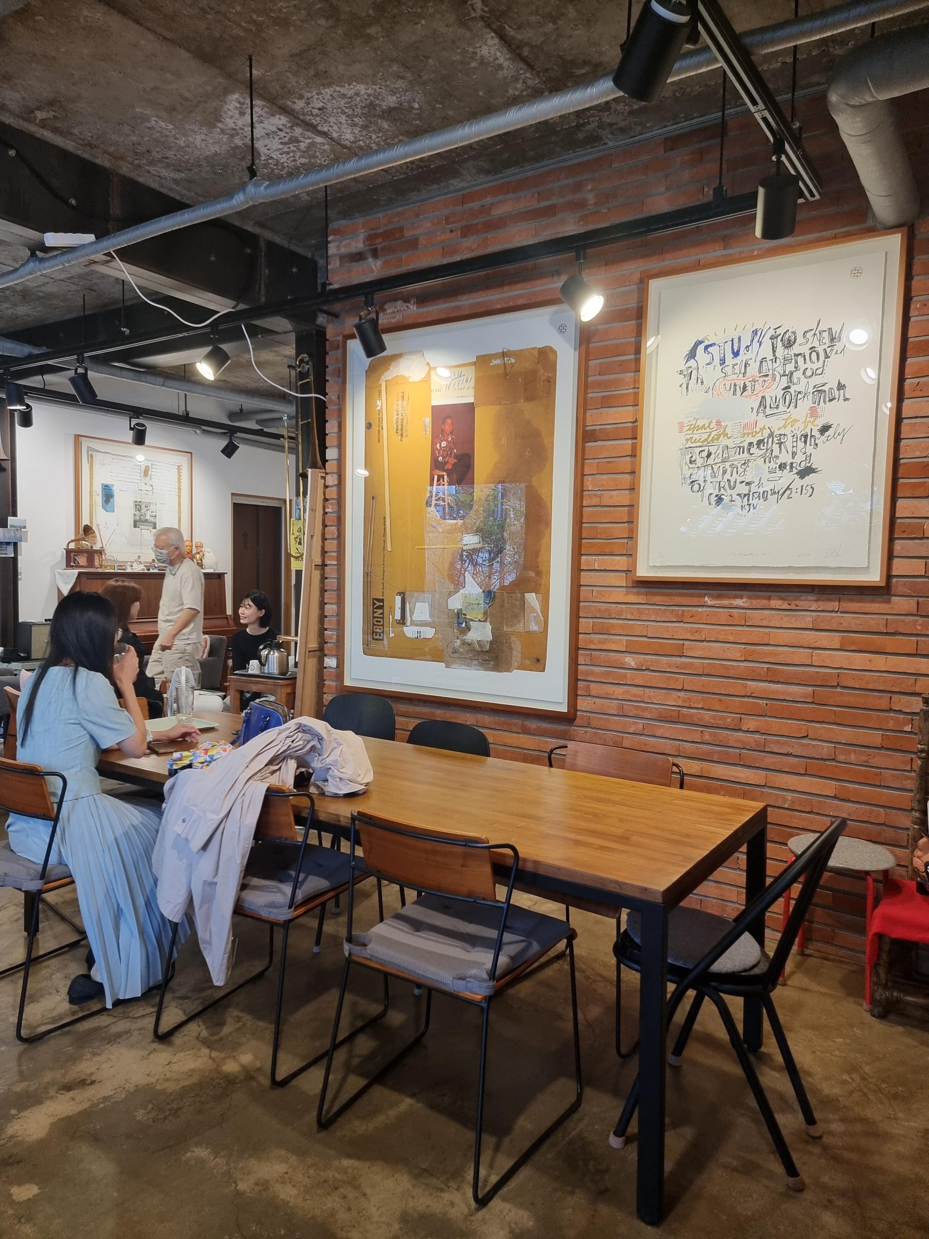 카페-내부-긴테이블-벽면-액자-작품