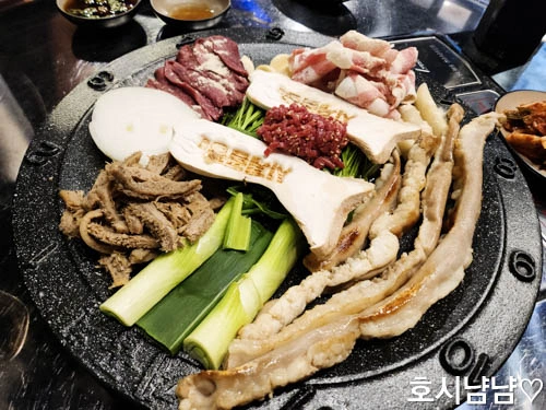 시계 숫자가 새겨진 특별한 불판에 곱창 모둠과 육회가 한 판 세팅된 모습