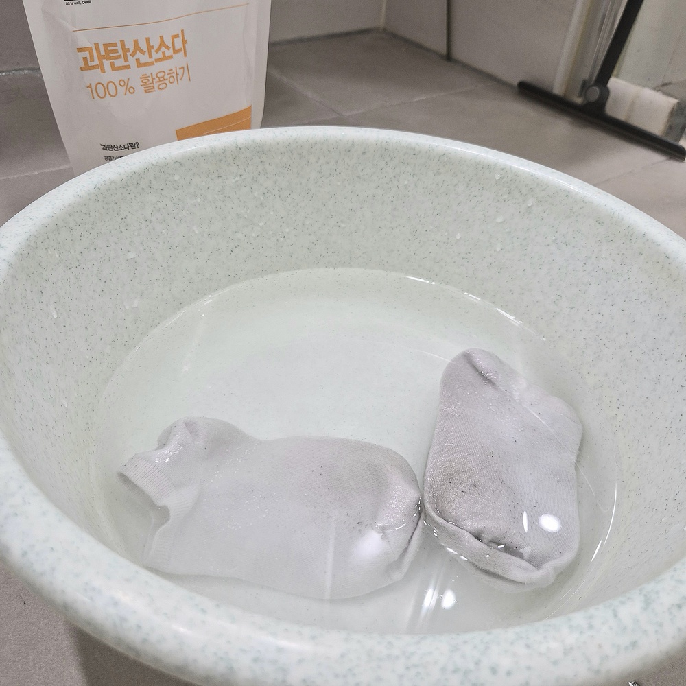 과탄산소다를 푼 물에 흰 양말을 담가 찌든 때를 관리하는 모습