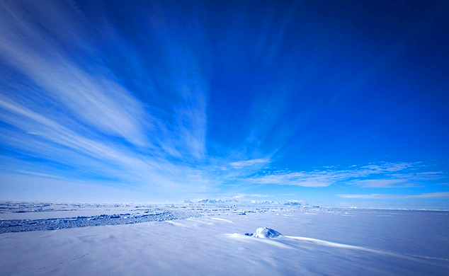 파란 하늘이 지평선에 다다르고 땅에는 하얀 빙판이 깔려있다.